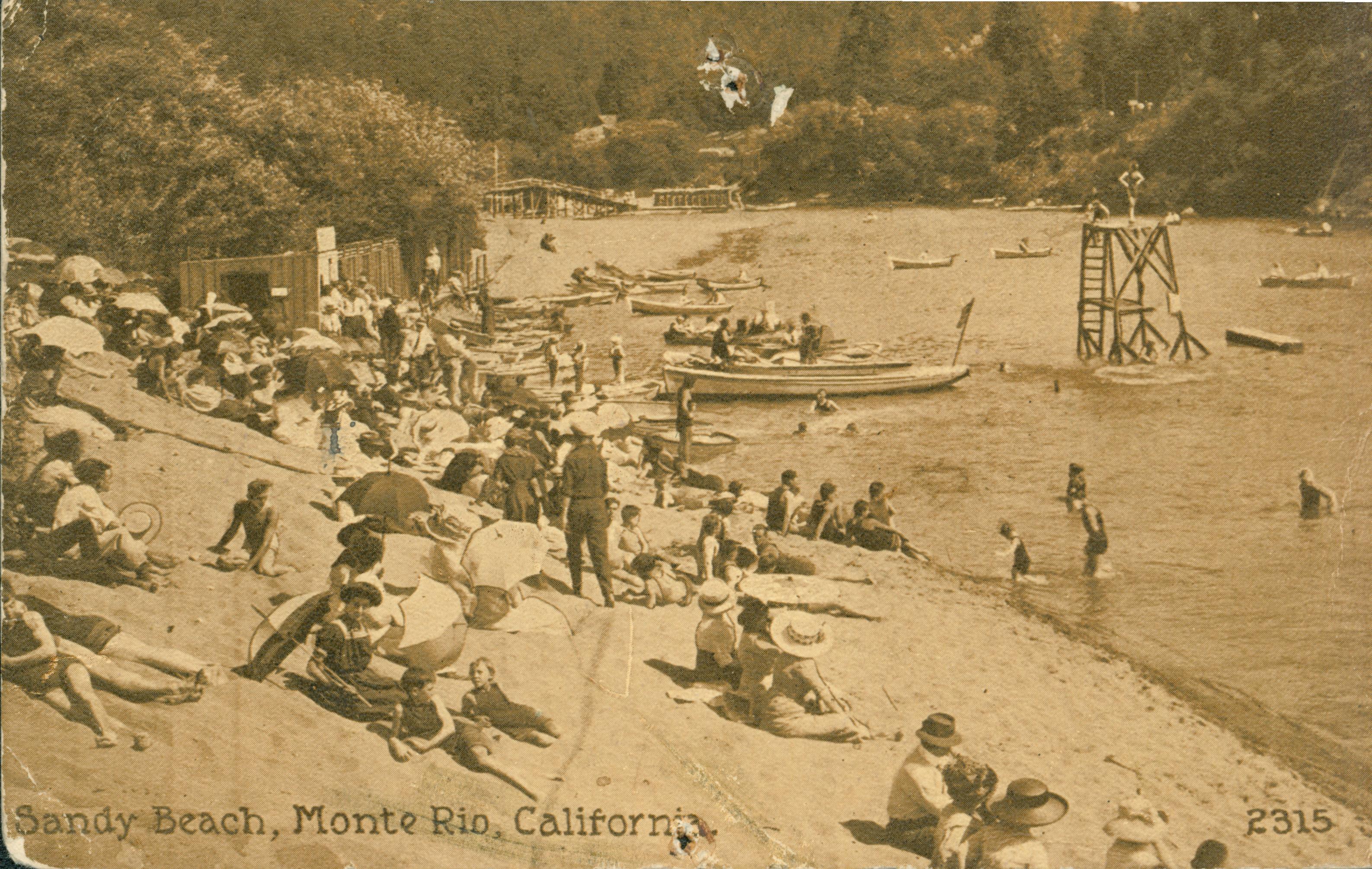 Shows a crowded beach filled with sunbathers, swimmers and boaters